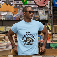 Man wearing a light blue t-shirt with 'My Strongest Daddy' graphic in a music store.
