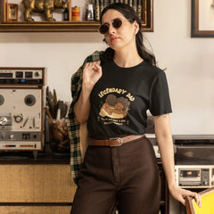 Woman wearing a black t-shirt with graphic design in a room with vintage decor