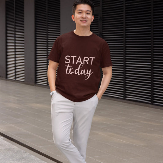 Man wearing a brown t-shirt with 'Start Today' text, standing outdoors.