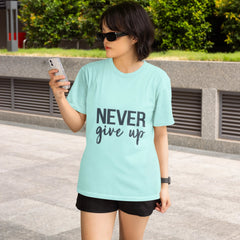 Woman wearing a light blue t-shirt with 'NEVER give up' text, standing outdoors.