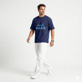 Man wearing a navy blue t-shirt with 'work HARD' text on a white background