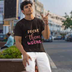 Man wearing a black t-shirt with 'PROVE THEM WRONG' text in an urban setting