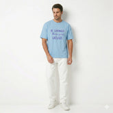 Man wearing a light blue t-shirt with motivational text on a white background