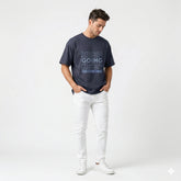 Man wearing a navy blue t-shirt with motivational text on a white background