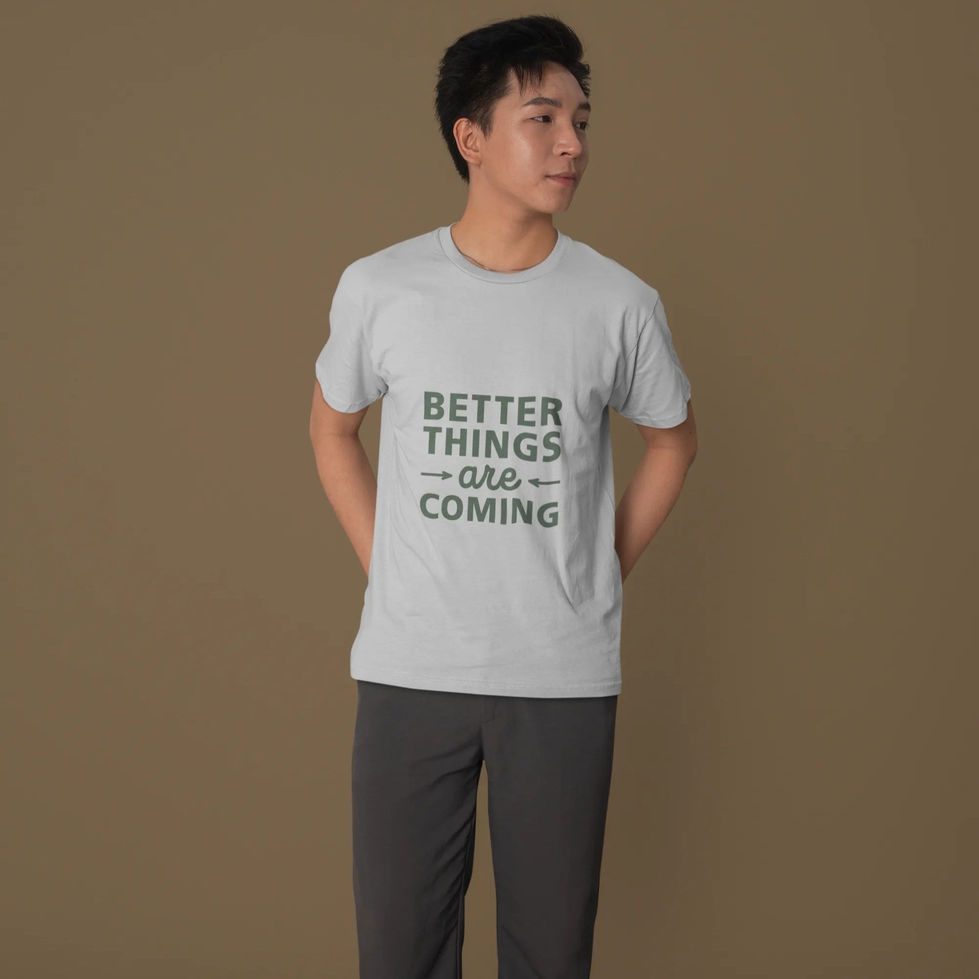 Person wearing a gray t-shirt with 'Better Things Are Coming' text on a brown background