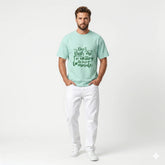 Man wearing a light green t-shirt with text on a white background