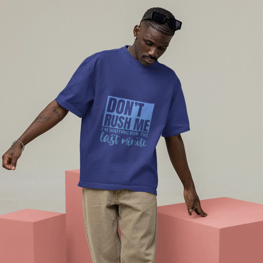 Person wearing a blue t-shirt with text, standing on pink blocks against a plain background