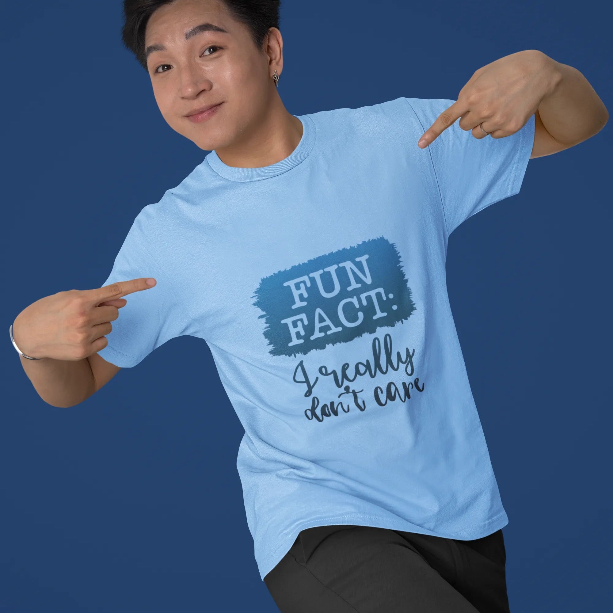Person wearing a light blue t-shirt with a humorous design on a solid background