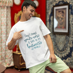 Man wearing a white t-shirt with text in a room with red walls and decorative elements.