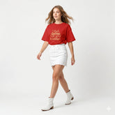 Woman wearing a red t-shirt with text and white skirt on a white background
