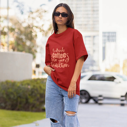 Woman wearing a red oversized t-shirt and ripped jeans on a city street.