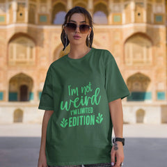 Person wearing a green t-shirt with text in front of an architectural building