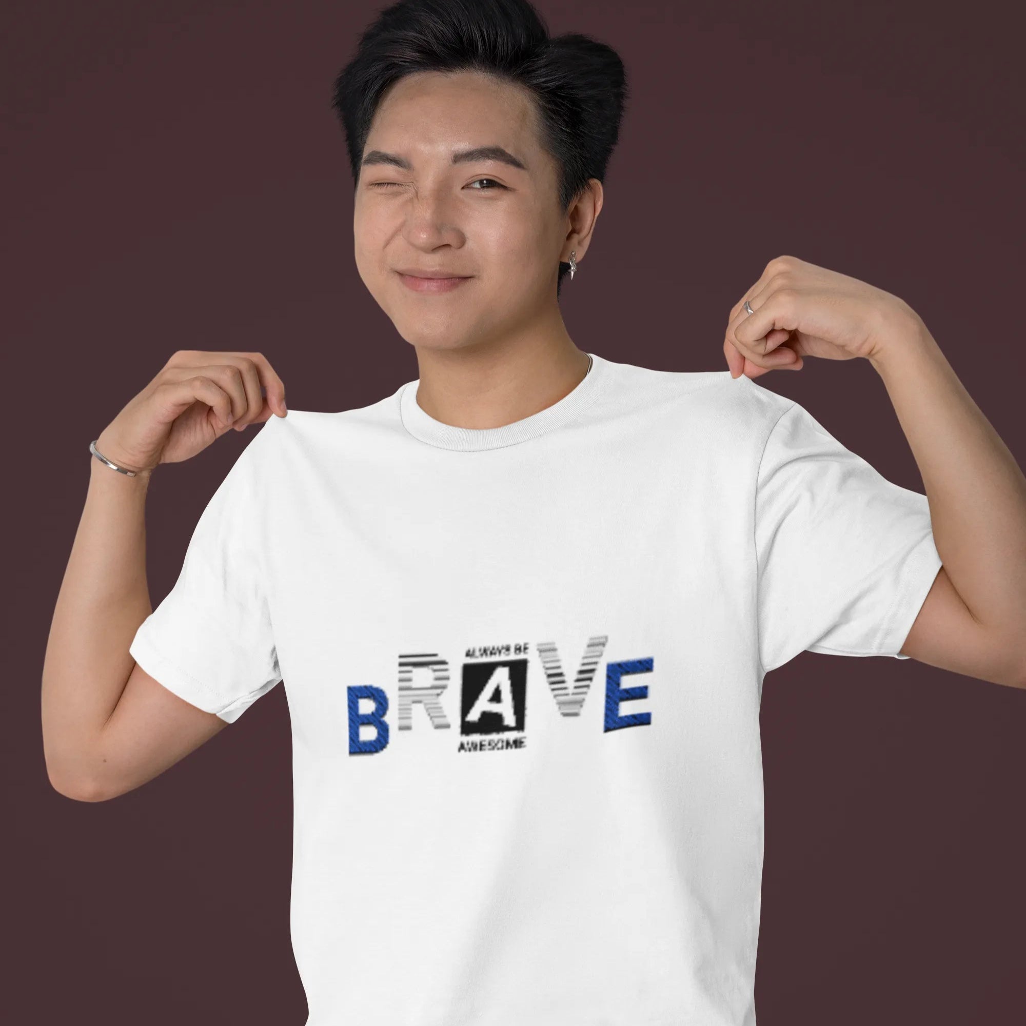 Person wearing a white t-shirt with 'BRAVE' text design on a dark background