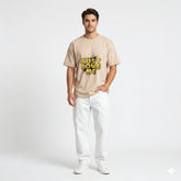 Man wearing a t-shirt with 'Just Love Me' text in a decorated room.