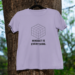 Light purple t-shirt with a geometric design and text hanging on a tree