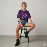 Woman wearing a purple t-shirt with 'Don't Forget To Smile' text outdoors.