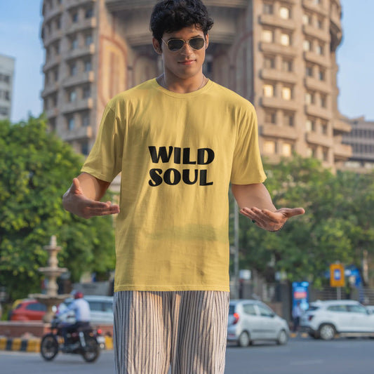 Person wearing a yellow t-shirt with 'WILD SOUL' text in an urban setting