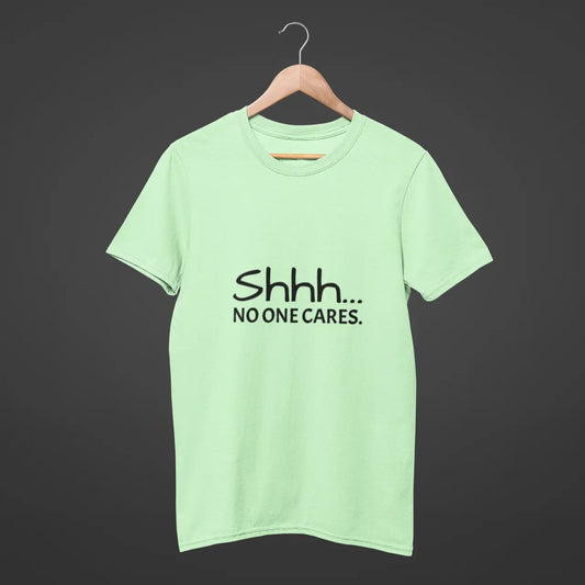 Light green t-shirt with 'Shhh... No one cares.' text on a dark background