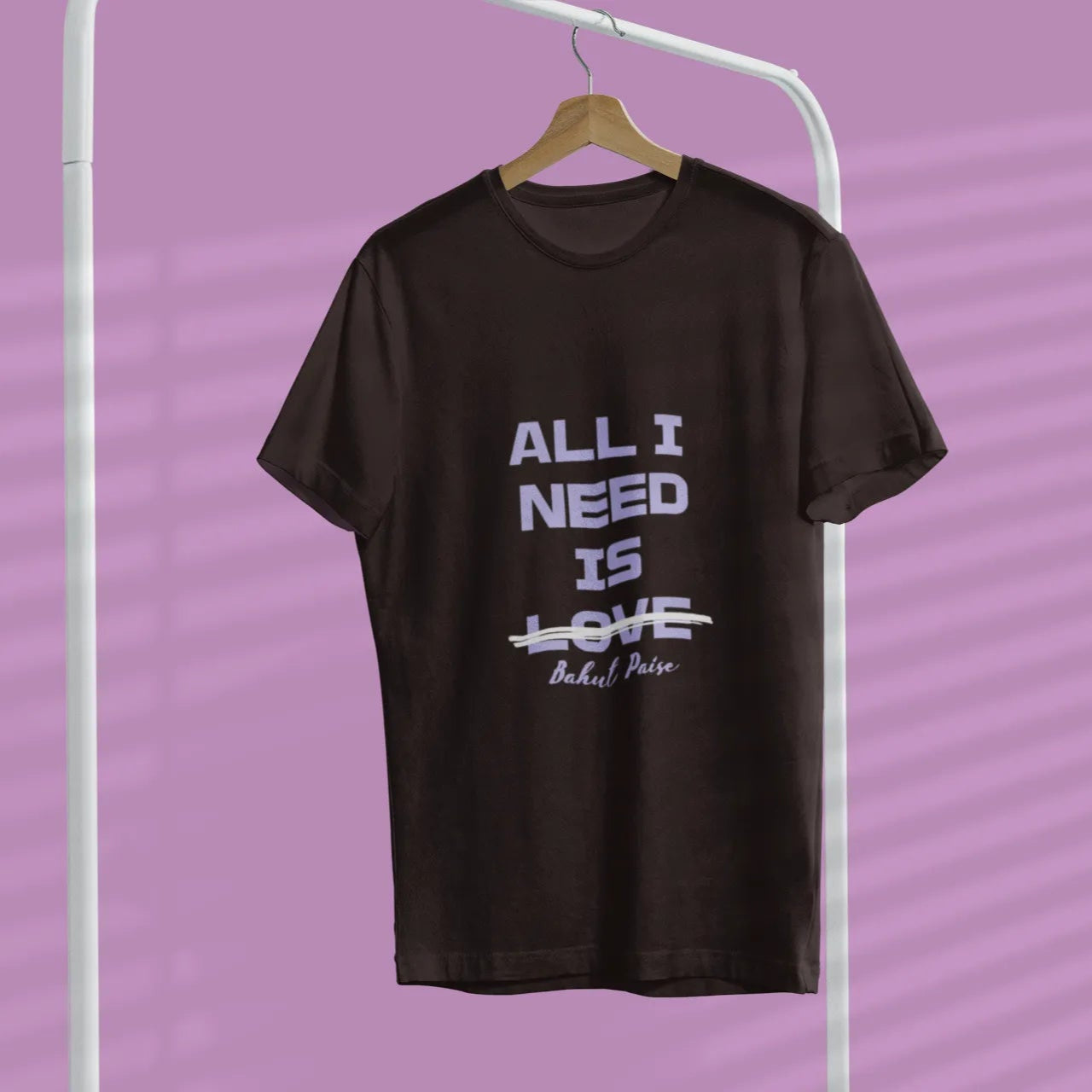 Black t-shirt with white text on a hanger against a purple background