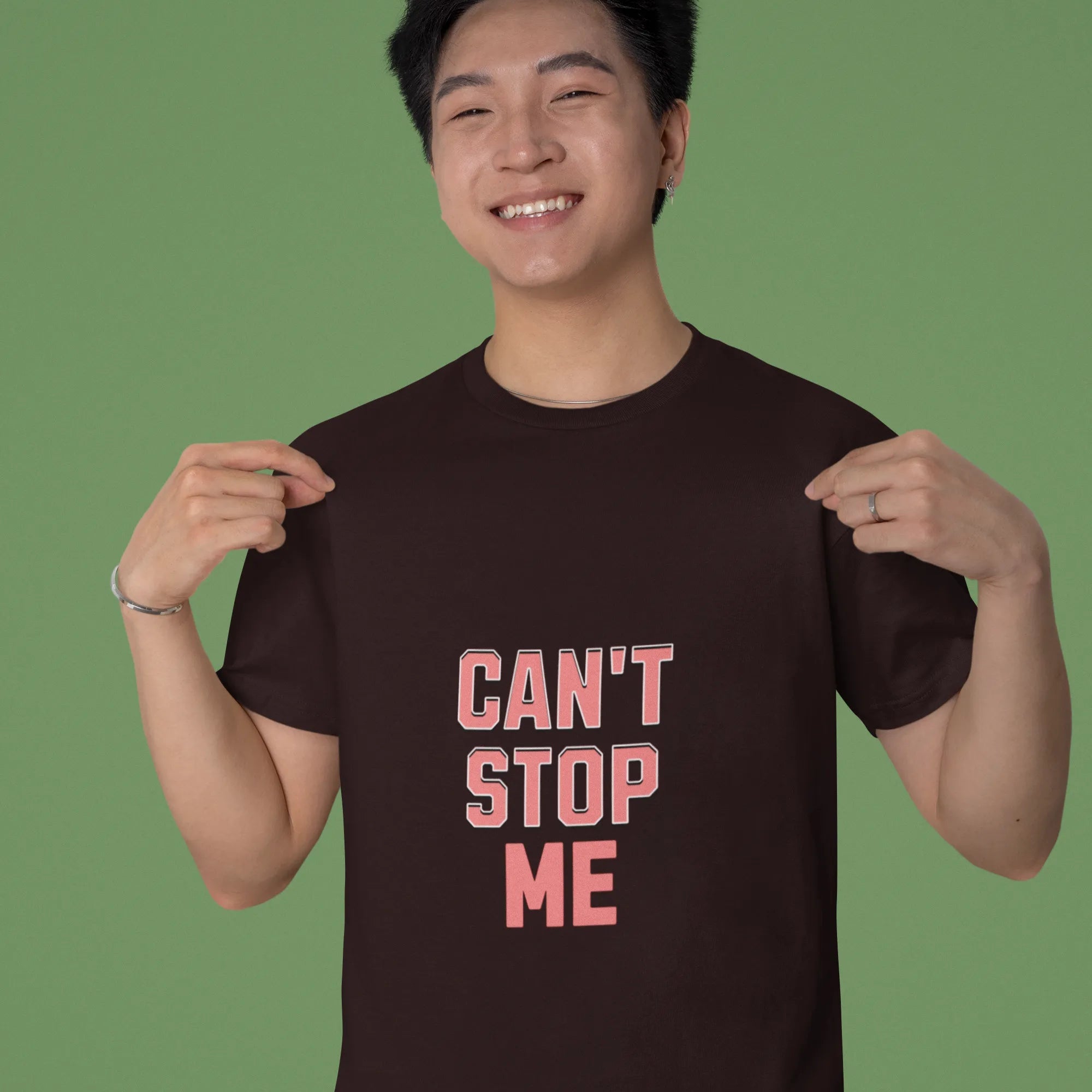 Person wearing a black t-shirt with 'CAN'T STOP ME' text on a green background