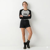 Person wearing a black and gray 'TIRED.' shirt with black shorts on a white background