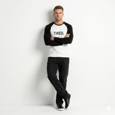 Man wearing a black and white long-sleeve shirt with 'TIRED.' text on a white background