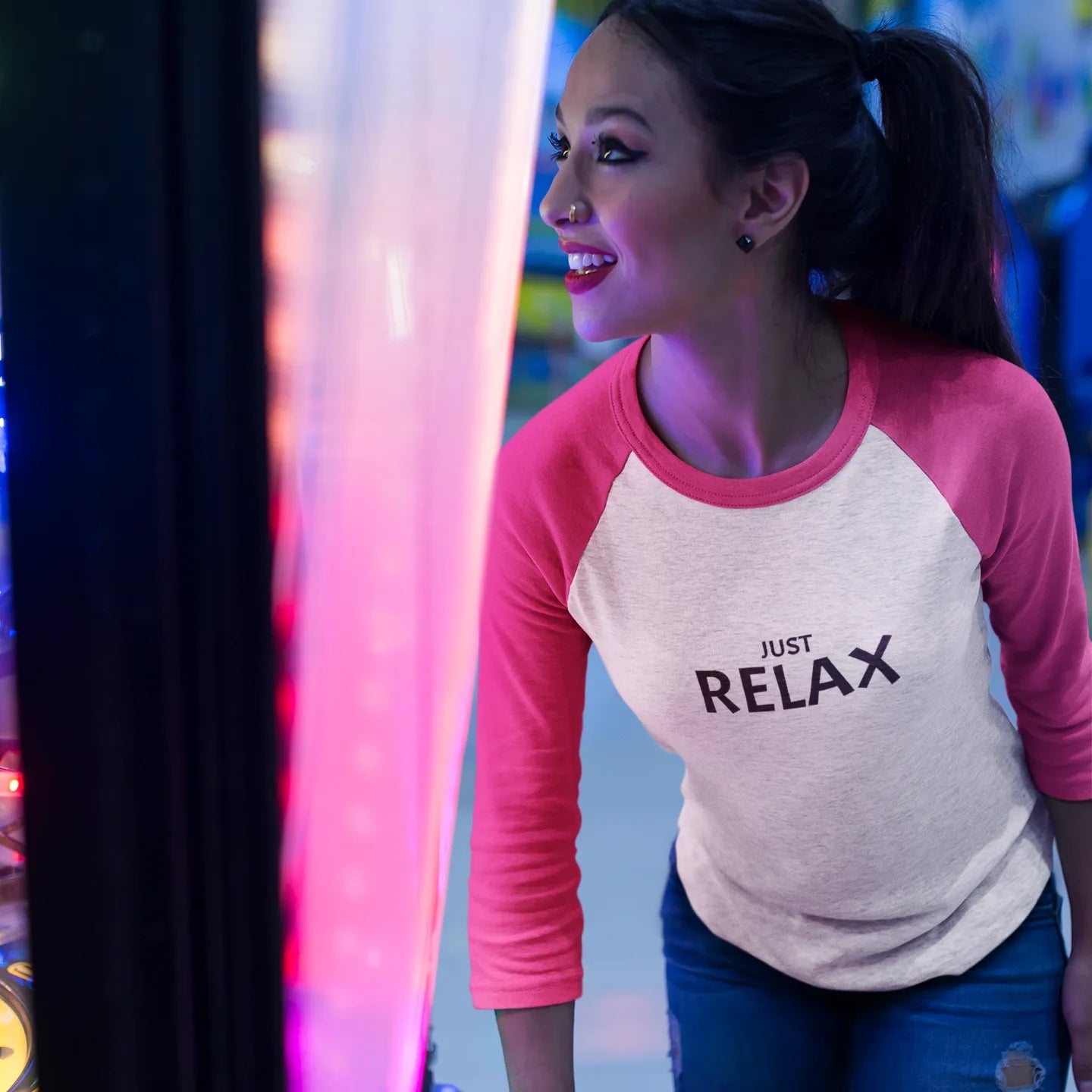 Woman wearing a 'Just Relax' shirt in an arcade setting
