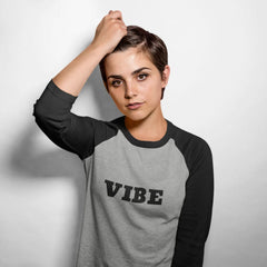 Person wearing a gray and black baseball shirt with 'VIBE' text on a white background
