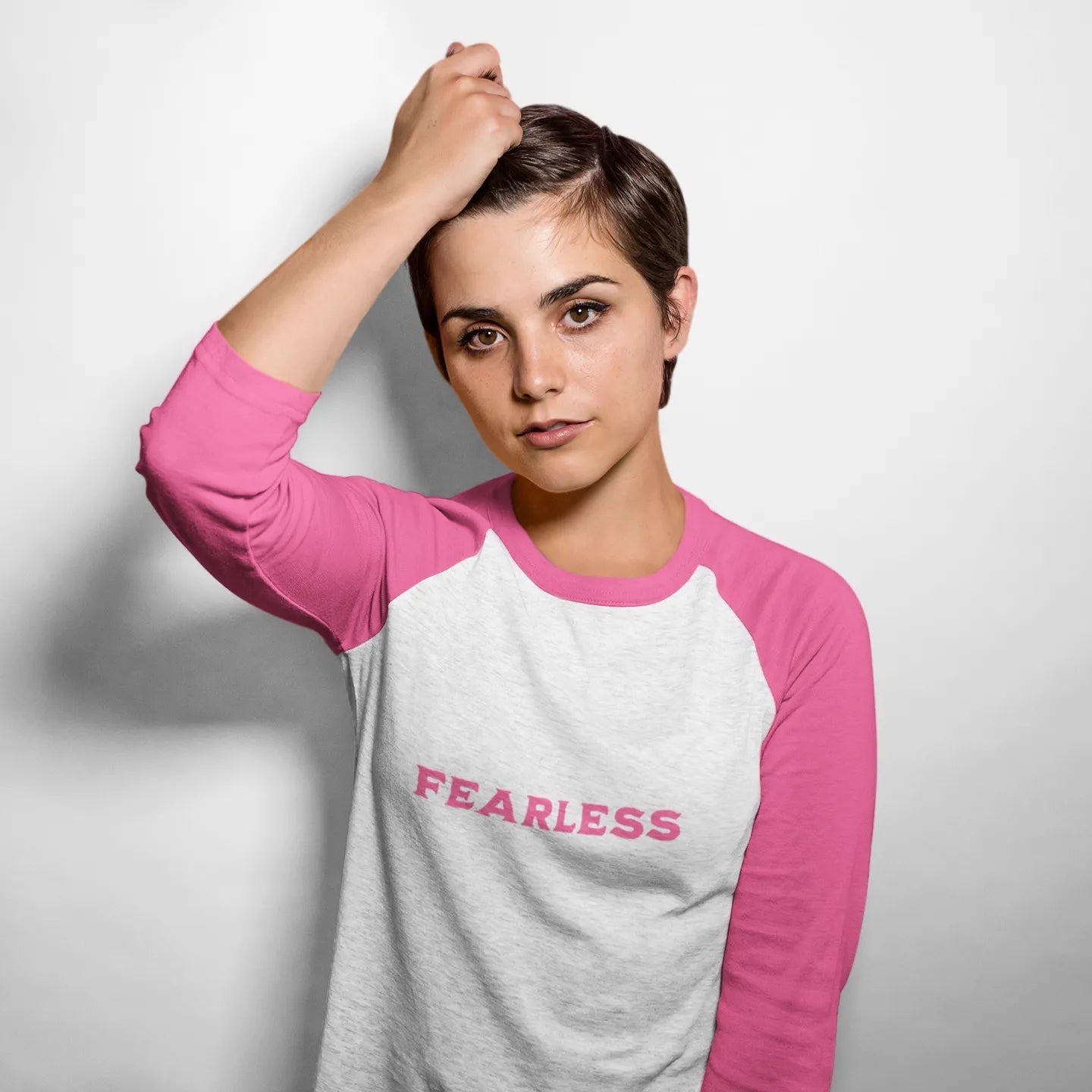 Person wearing a pink and gray 'FEARLESS' shirt against a white background