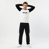Person wearing a white and black long-sleeve shirt with 'NATURE.' text on a white background