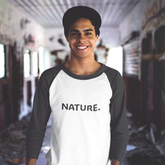Person wearing a white and black baseball shirt with 'NATURE.' text in an indoor setting.