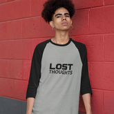 Person wearing a 'Lost Thoughts' shirt against a red brick wall