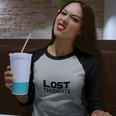 Woman wearing a 'Lost Thoughts' shirt holding a drink with a straw.