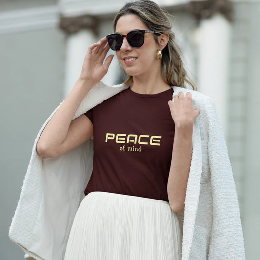 Woman wearing a t-shirt with 'Peace of Mind' text outdoors