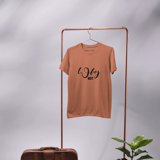 Brown t-shirt on a hanger with a vintage suitcase and potted plant on a gray background