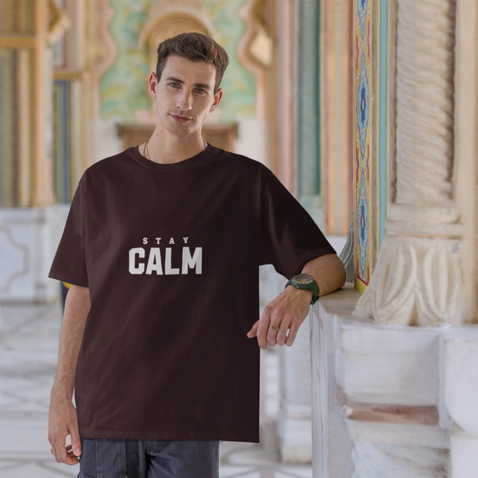 Man wearing a black t-shirt with 'Stay Calm' text in an ornate architectural setting