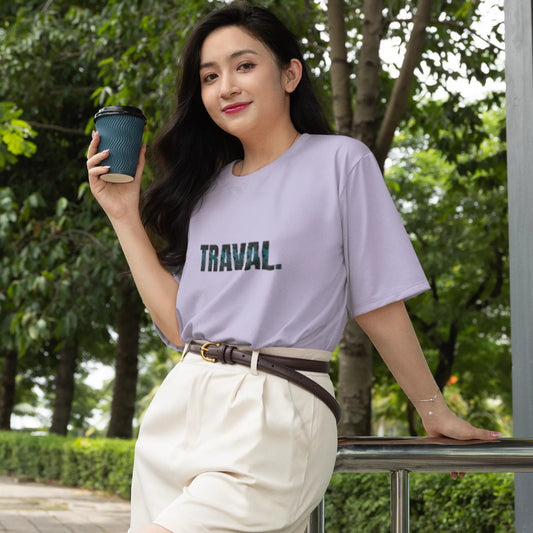 Woman wearing a 'TRAVAL' t-shirt holding a coffee cup outdoors.