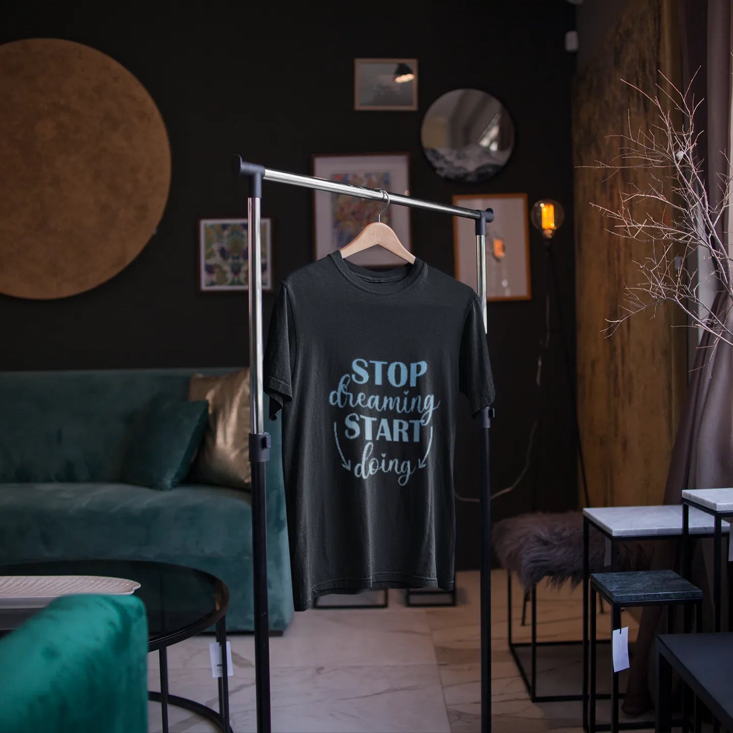 T-shirt with 'Stop dreaming, start living' text on a hanger in a room with a green sofa and decorative elements.