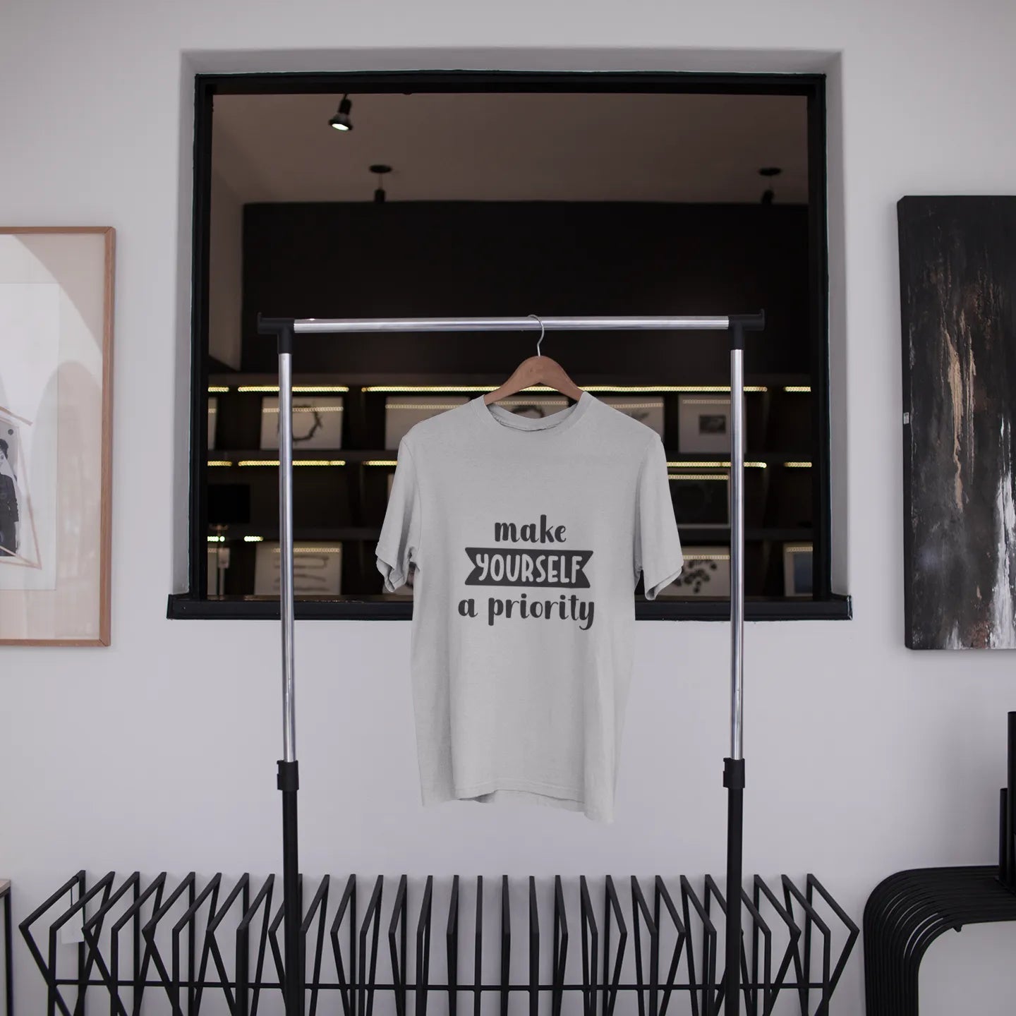 White t-shirt with text hanging on a rack in a modern interior setting