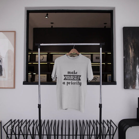 White t-shirt with text hanging on a rack in a modern interior setting