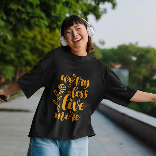 Person wearing a black t-shirt with gold text outdoors