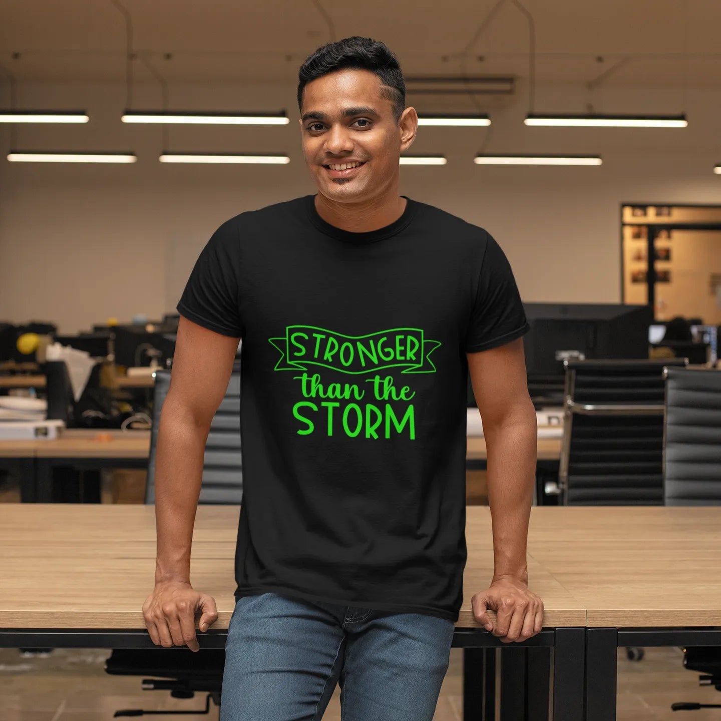 Person wearing a black t-shirt with green text in an office setting
