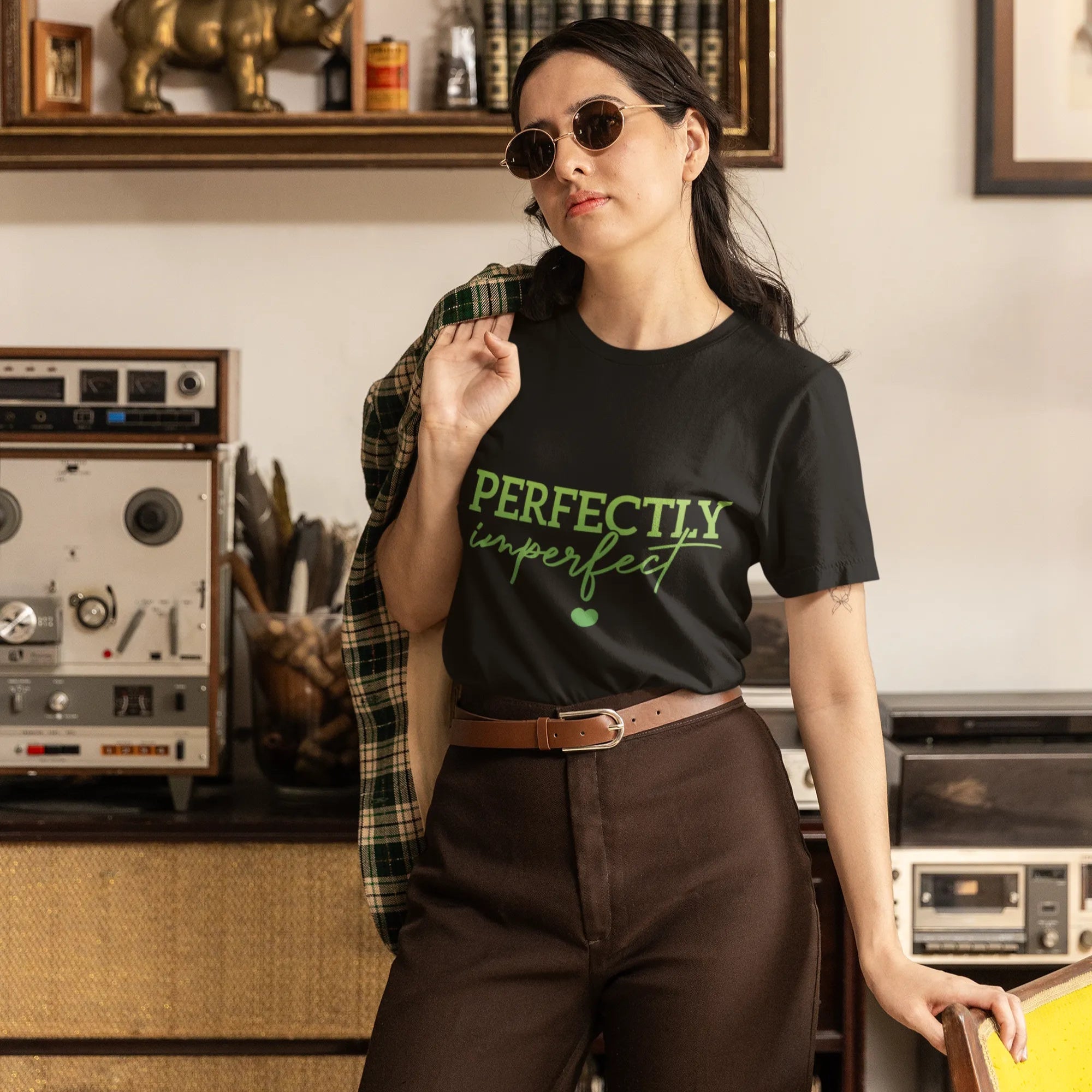 Woman wearing a black t-shirt with 'PERFECTLY imperfect' text in a vintage room.