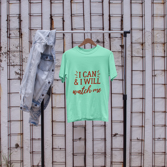 Green t-shirt with text on a rack with jeans and white sneakers in front of a textured wall.