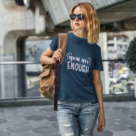 Woman wearing a t-shirt with 'you are ENOUGH' text in an urban setting