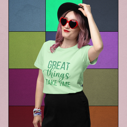 Person wearing a green t-shirt with text and black shorts against a colorful geometric background.