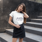 Woman wearing a white t-shirt with text standing on steps outdoors
