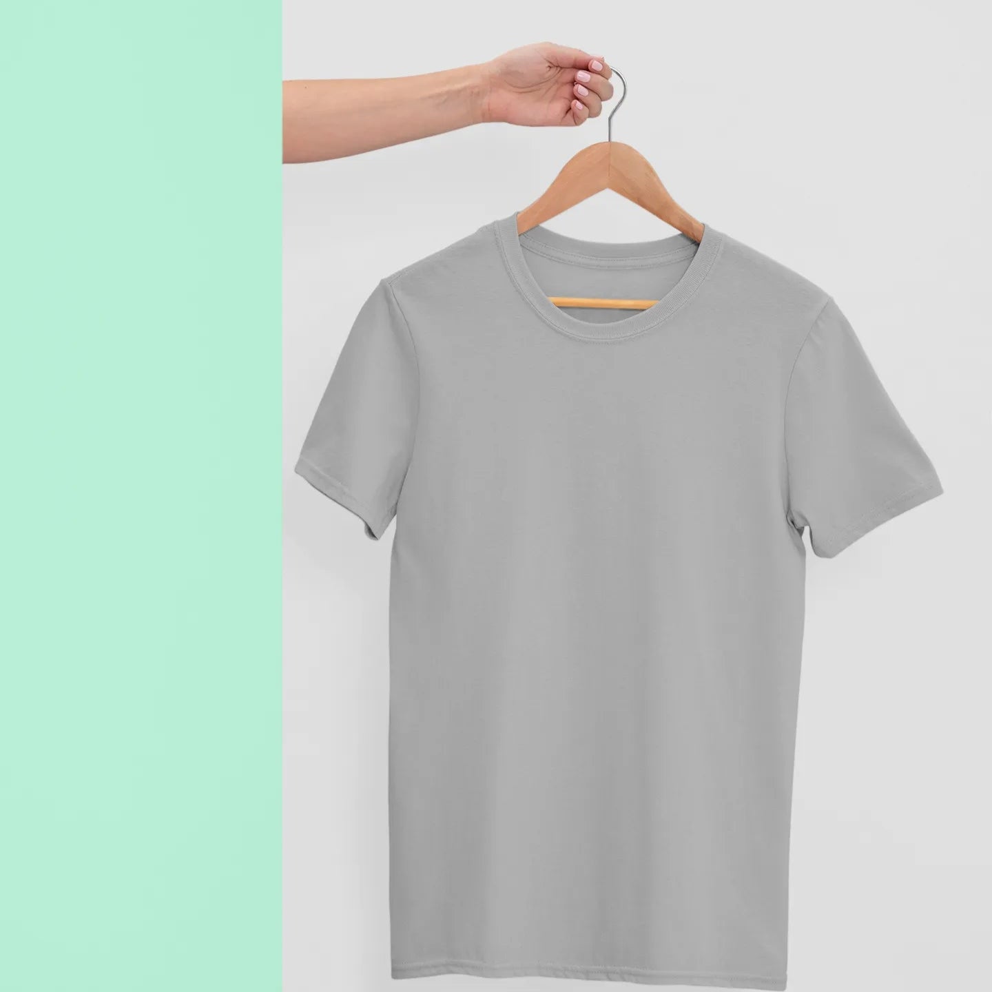 Gray t-shirt on a hanger against a light green background