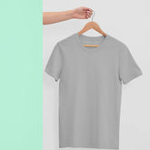Gray t-shirt on a hanger against a light green background