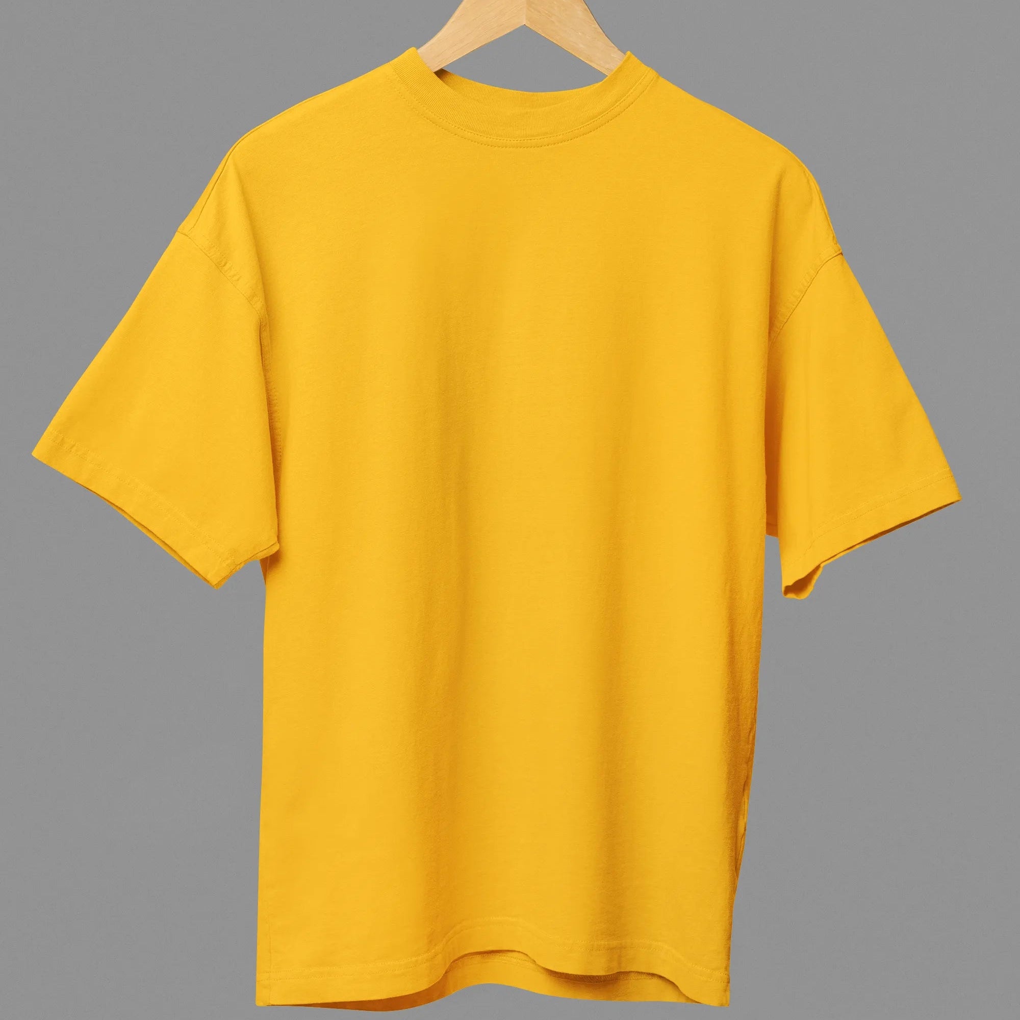 Yellow t-shirt on a hanger against a gray background